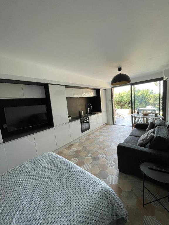 a living room with a bed and a kitchen at Famaméro in Sanary-sur-Mer