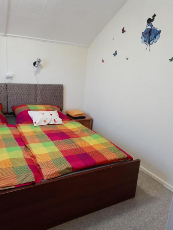 a bedroom with a bed with a colorful blanket at All-Inn K&ouml;re in Kisk&ouml;re