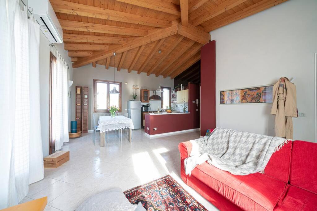 サン・フェリーチェ・デル・ベナーコにあるAppartamento Antica Corteのリビングルーム(赤いソファ付)、キッチン