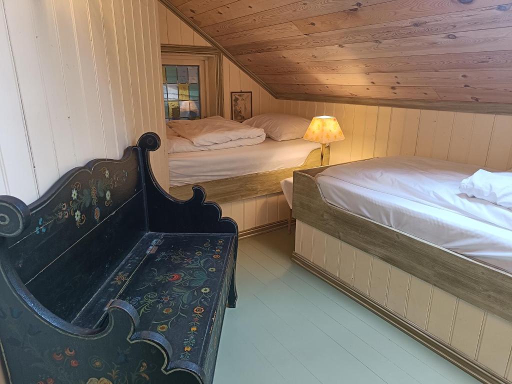 um quarto com duas camas e um banco num quarto em Orheimstunet - Gårdsferie for storfamilien der også hunden er velkommen em Orhejm