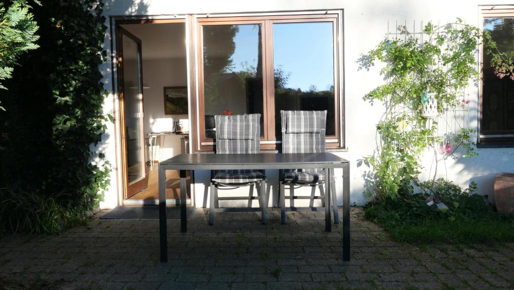 Am Hirschberg في باد هينديلانغ: طاولة وكراسي أمام المنزل