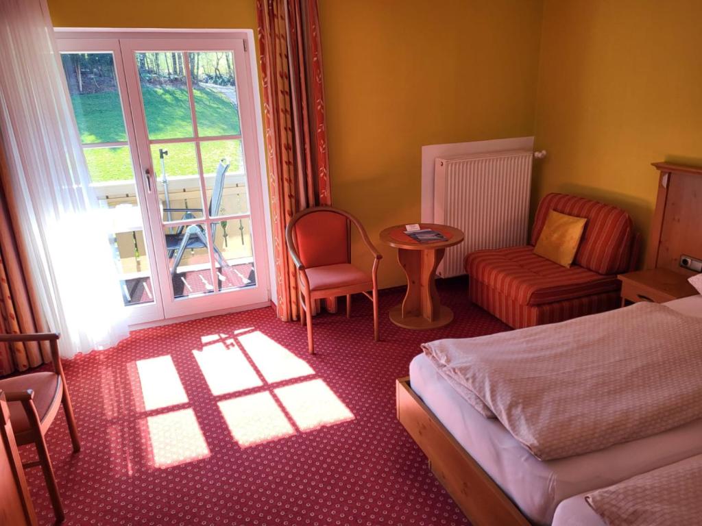 Schlafzimmer mit einem Bett, einem Tisch und einem Fenster in der Unterkunft Gästehaus Schwarz in Prien am Chiemsee