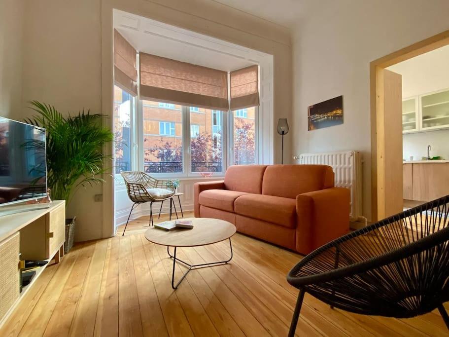 ein Wohnzimmer mit einem Sofa und einem Tisch in der Unterkunft Les Valcaprimontoises … en ville ! in Lüttich