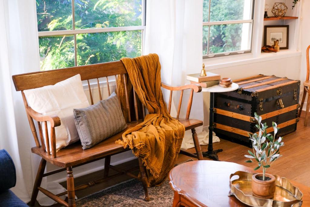 a living room with a wooden chair with a blanket at Cozy Renovated Vintage Modern House Downtown! in Fort Myers