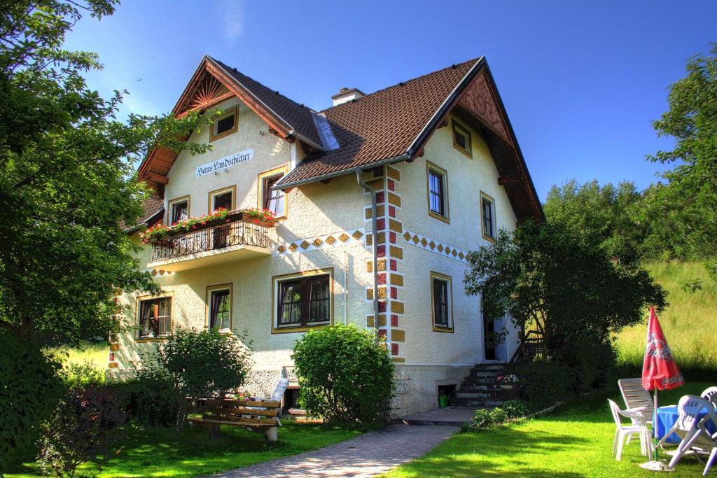 a large white house with a balcony and a yard at Villa Löcker in Mariapfarr