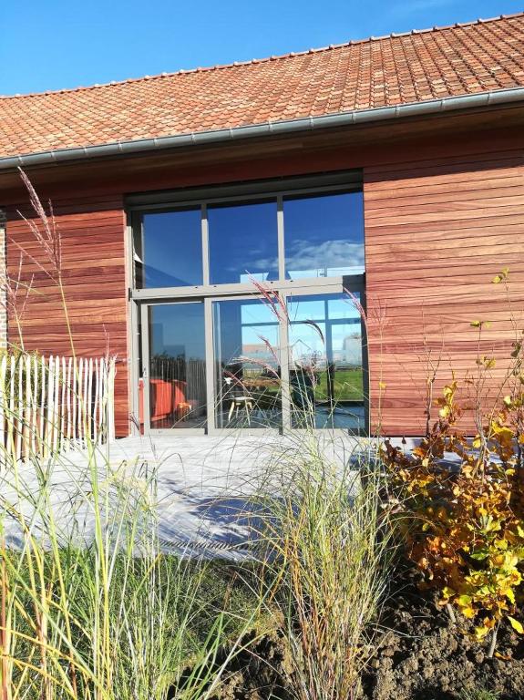 une maison avec une grande fenêtre sur le côté dans l'établissement La grange des deux pays, à Nieppe