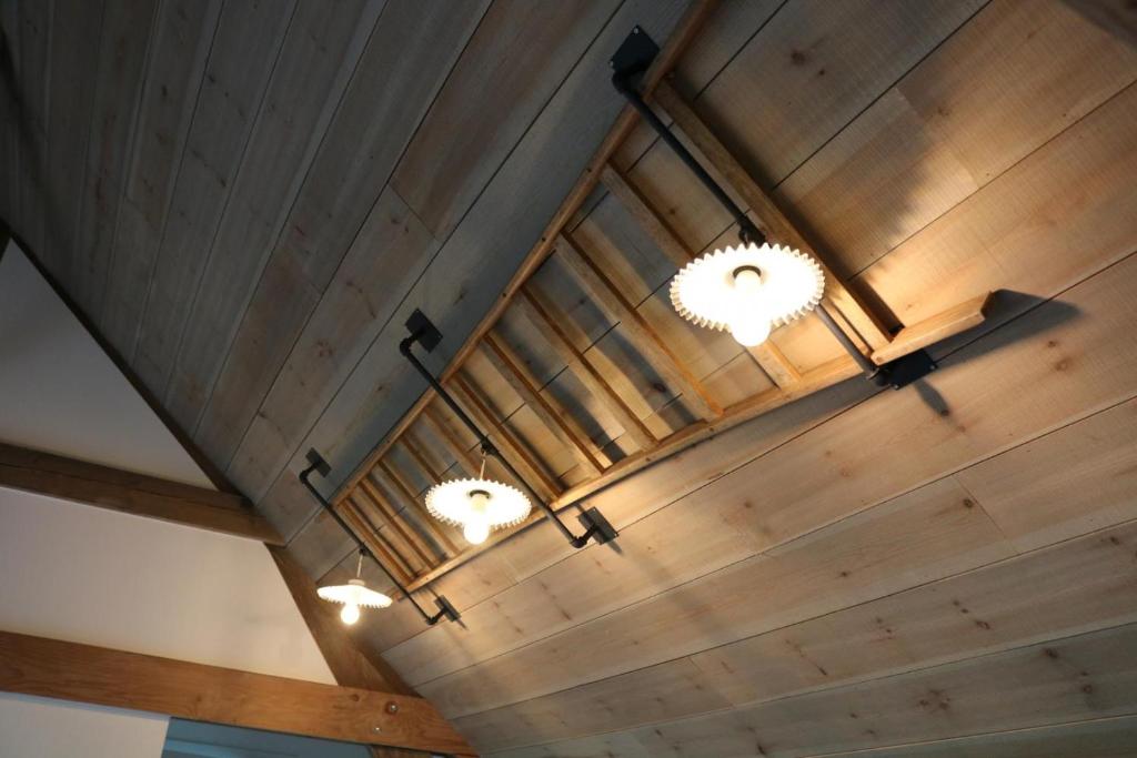 un soffitto in legno con due luci sopra di La grange des deux pays a Nieppe