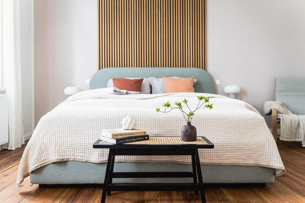 a bedroom with a blue bed with a table at HORAMI Villa - OKYU Apartment in Malchow