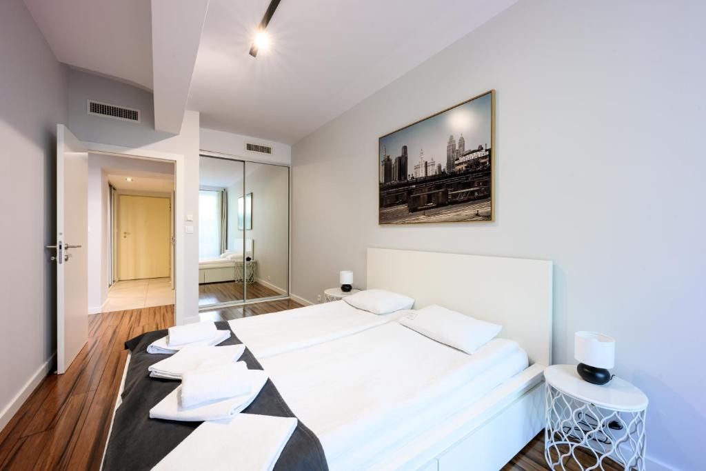 a bedroom with a large white bed with white pillows at Premium Apartments by Wawel Castle in Krakow