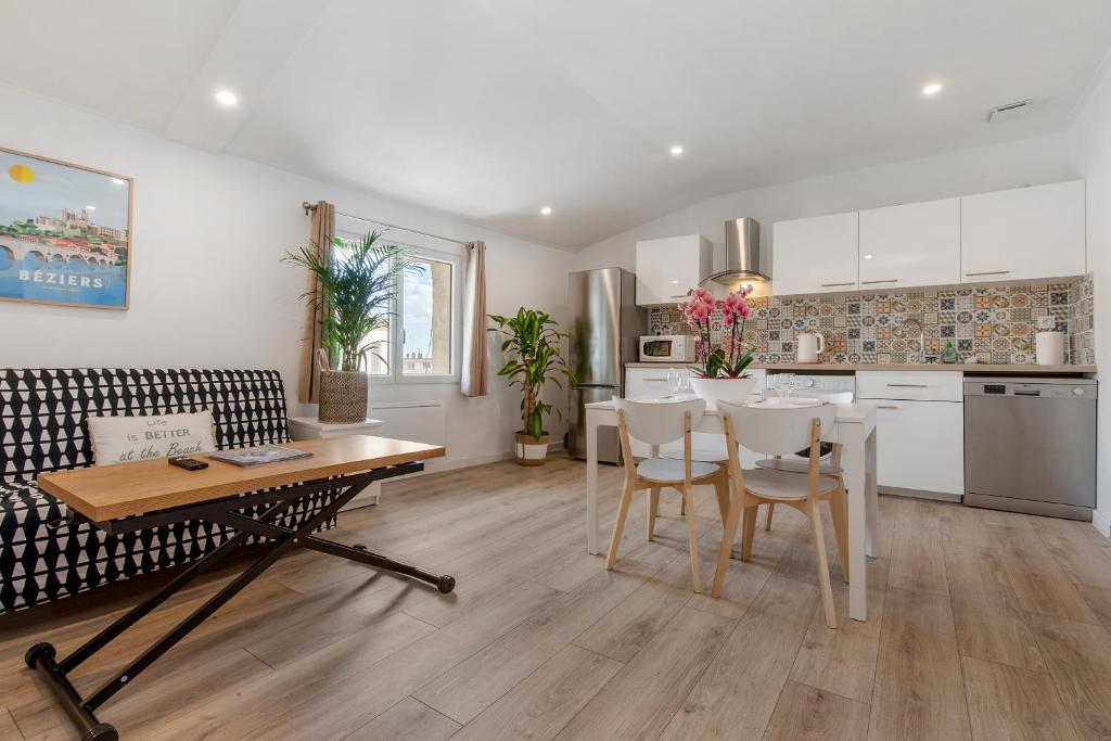 a kitchen and living room with a table and chairs at Flamingo Center Clemenceau in Béziers