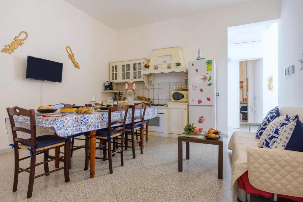eine Küche und ein Esszimmer mit einem Tisch und Stühlen in der Unterkunft Residence il Porto di Mare in Porto Cesareo