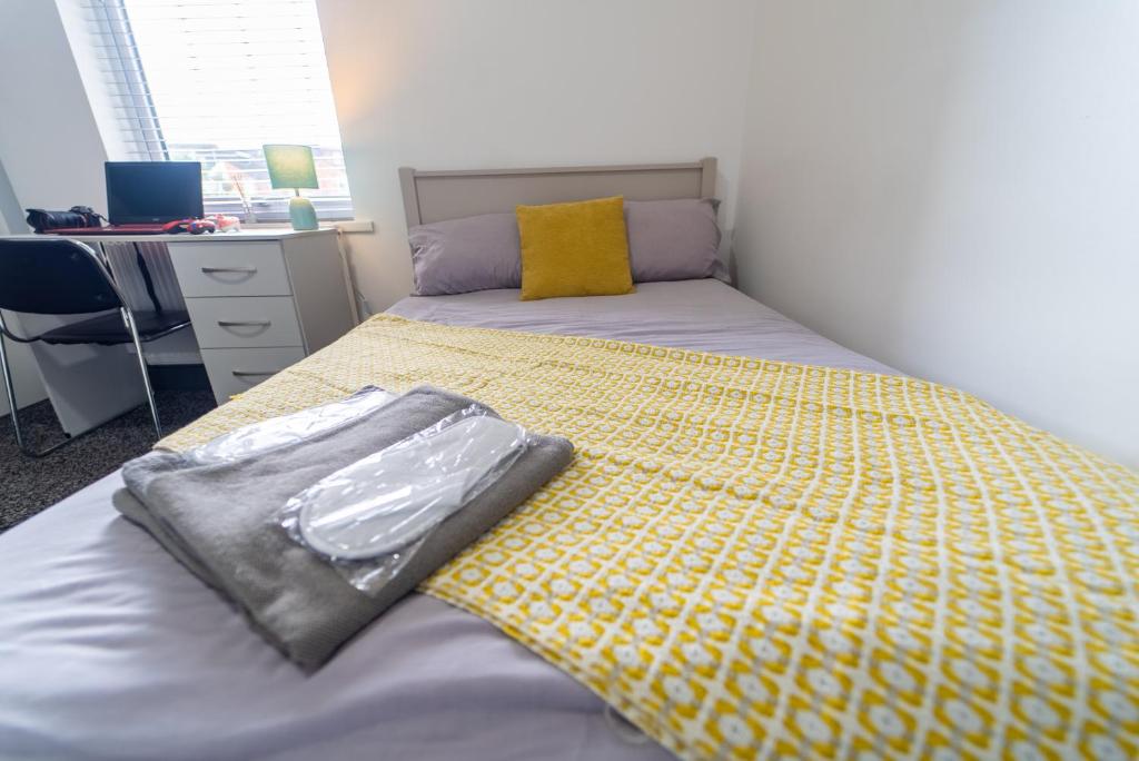 1 Schlafzimmer mit 2 Betten und einer gelben Decke in der Unterkunft Impeccable 1-Bed Studio in Birmingham in Birmingham