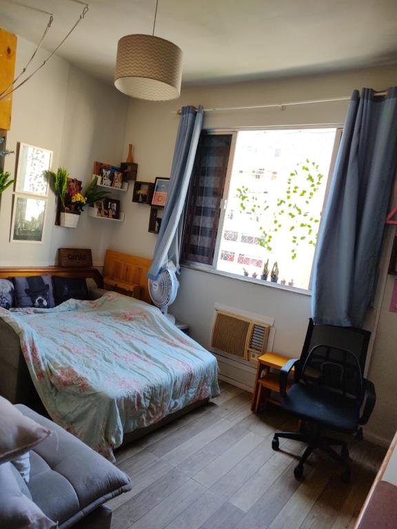 a bedroom with a bed and a chair and a window at Apt Flamengo colado metrô praias in Rio de Janeiro