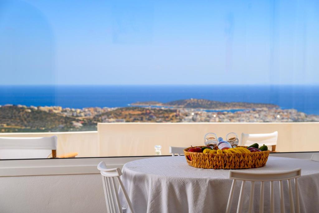 a table with a basket of fruit and pair of shoes at Althea Villa by breathtaking view in Agios Nikolaos