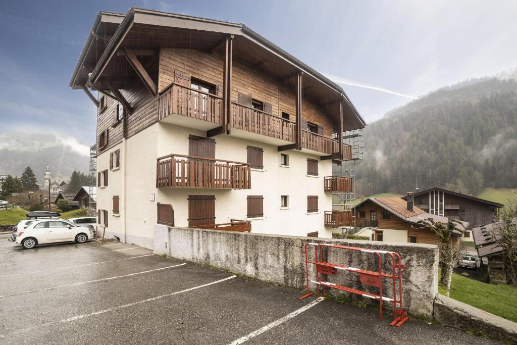 a building with a car parked in a parking lot at Studio cabine Le Charvet in Le Grand-Bornand