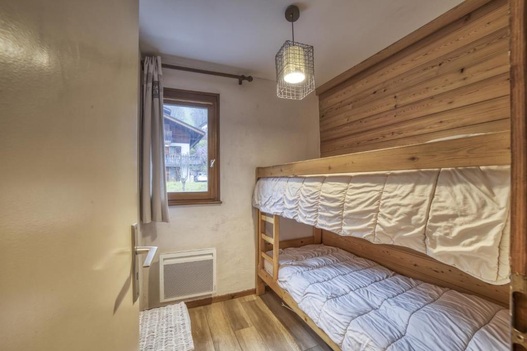 a bedroom with two bunk beds and a window at Studio cabine Le Charvet in Le Grand-Bornand