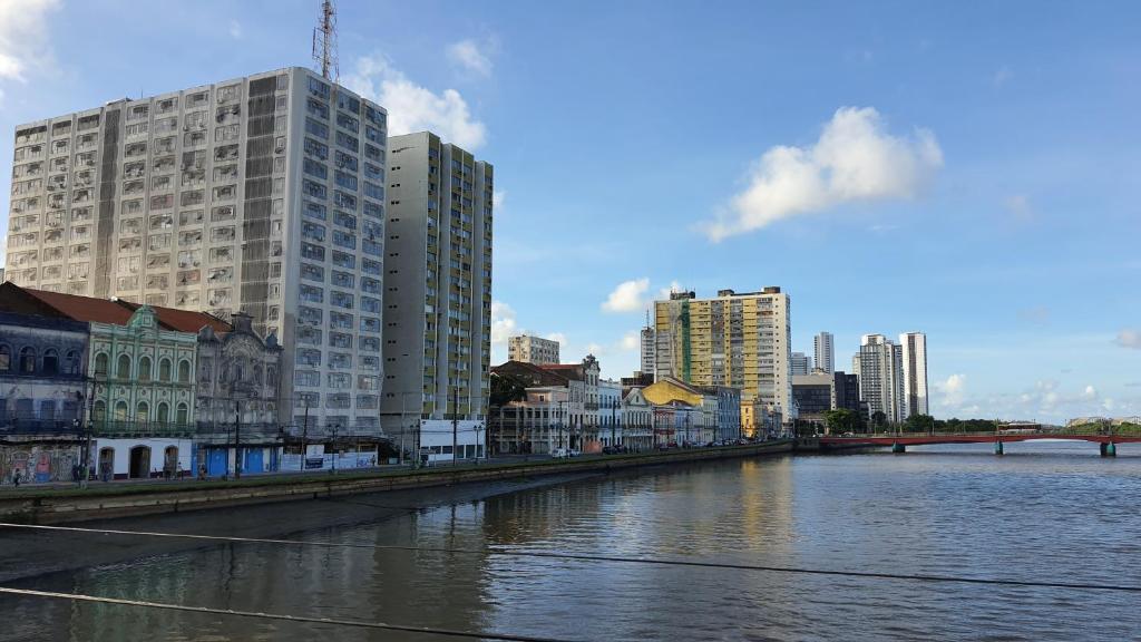 uma cidade com edifícios altos e um rio com edifícios em Studio Aurora - Recife em Recife