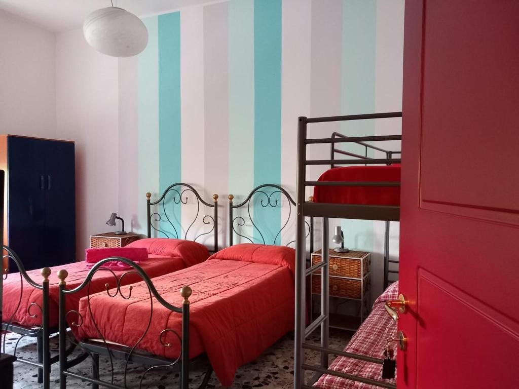 1 Schlafzimmer mit 2 Etagenbetten mit roter Bettwäsche in der Unterkunft B&B delle Arti in Crema