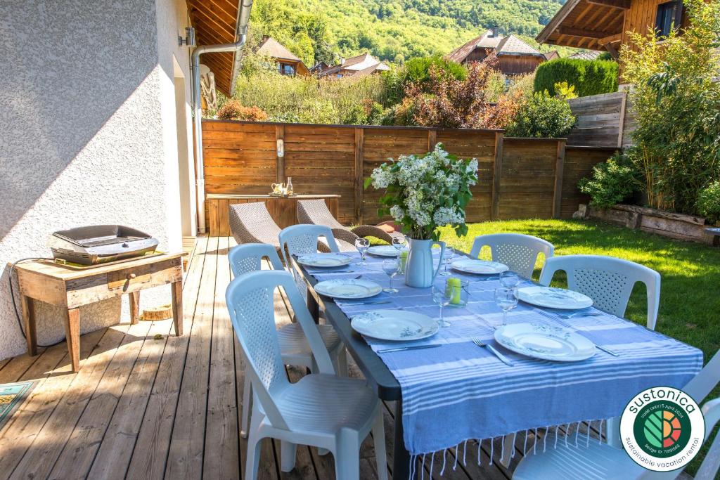 un tavolo con una tovaglia blu su un patio di Sous le soleil de Lanfon - Maison au Calme avec jardin clos, LLA Selections by Location Lac Annecy a La Pirraz