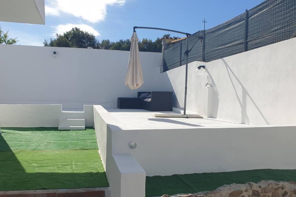 una casa blanca con un patio con césped verde en Mare e Vacanze, en Villa San Pietro