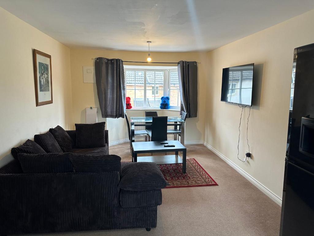 a living room with a couch and a table at Lovely 2 Bedroom Family Holiday Home in Thamesmead