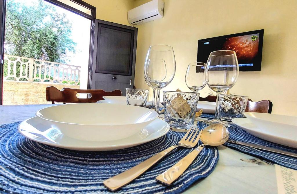 uma mesa com pratos e copos de vinho em Myrea House em Avola