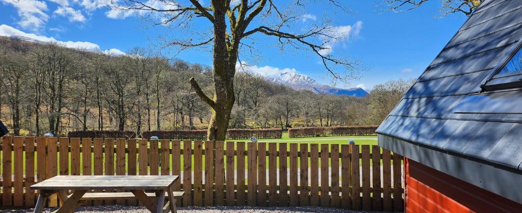 una mesa de picnic de madera frente a una valla en Bunroy Park en Fort William