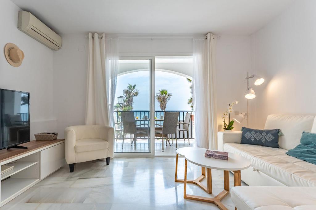salon z kanapą, telewizorem i stołem w obiekcie Dona Lola Micaela Beach front duplex apartment with open sea and beach views located between Marbella and Fuengirola - Costa del Sol - CS148 w mieście Mijas