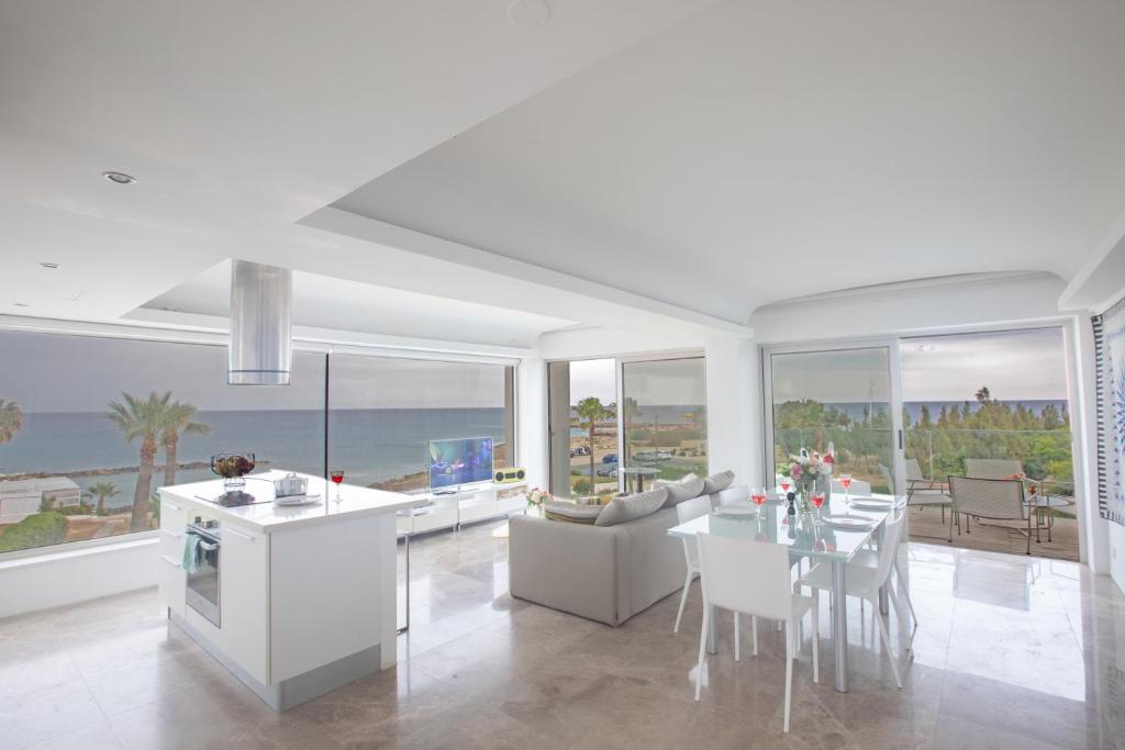 a kitchen and living room with a table and chairs at Thalassa Luxury Apartment in Protaras