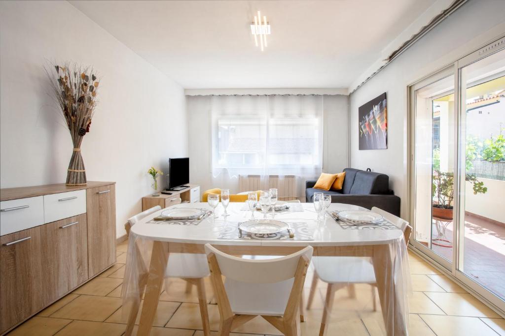 a dining room with a white table and chairs at Location La Londe in La Londe-les-Maures