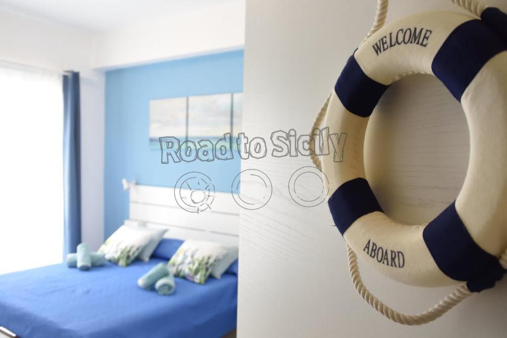 a room with a bed and a lifesaver on the wall at Mizar - Road to Sicily in Marina di Ragusa