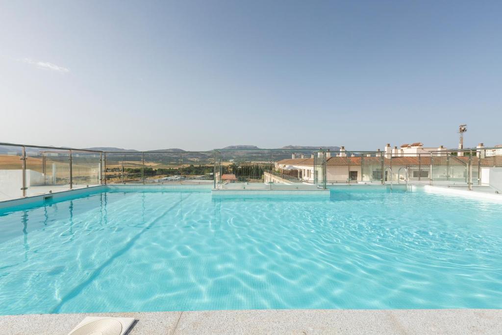 a large swimming pool with blue water at Apartamentos Martalia Áticos Deluxe in Ronda