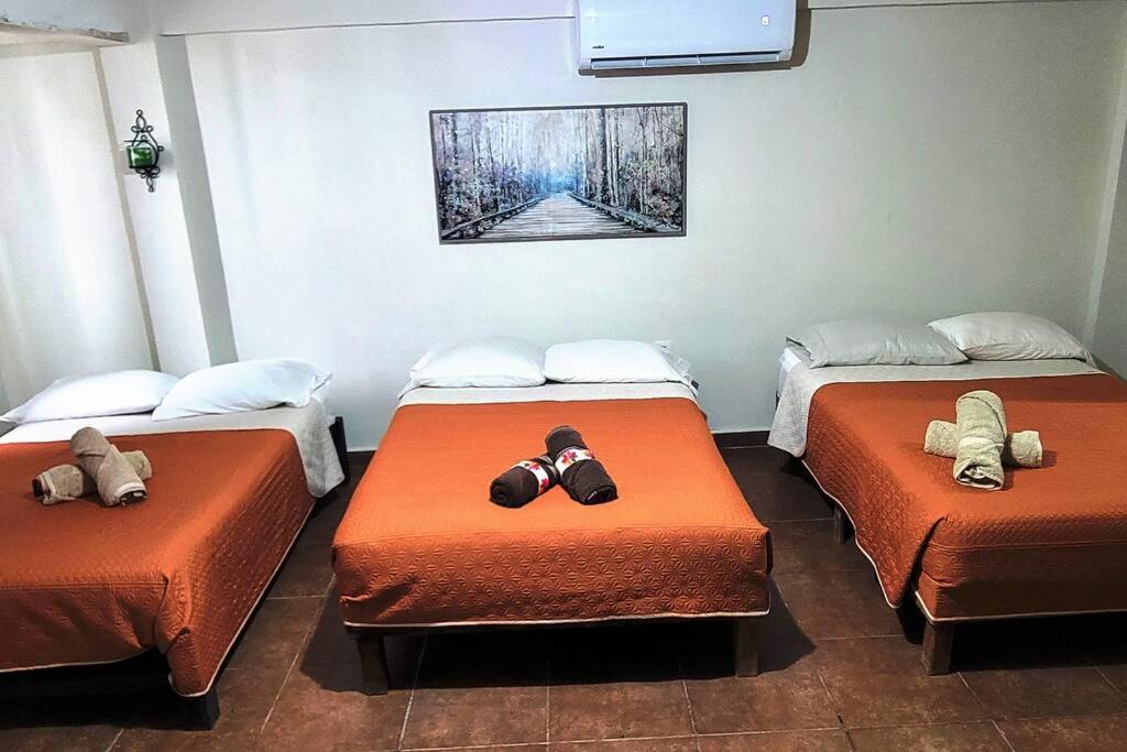 Una habitación con tres camas con zapatos. en Loft Centrico 3 camas matri, minisplit, estacionamiento, refrigerador,microhondas ( 3), en Ciudad Valles