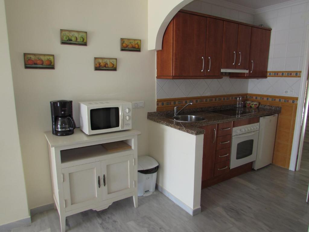 a small kitchen with a sink and a microwave at Home4Holidays in Nerja