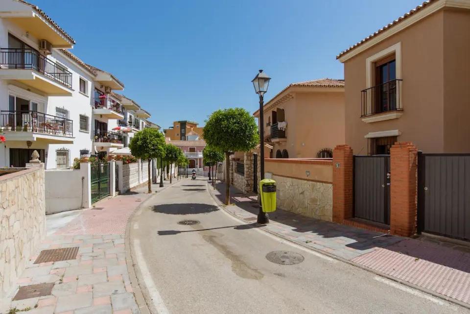 an empty street with buildings and a yellow fire hydrant at Habitación en Casa Vacacional Fuengirola in Fuengirola