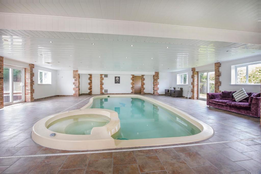 a large swimming pool in a large room at The Gardens - Stunning Farmhouse in York