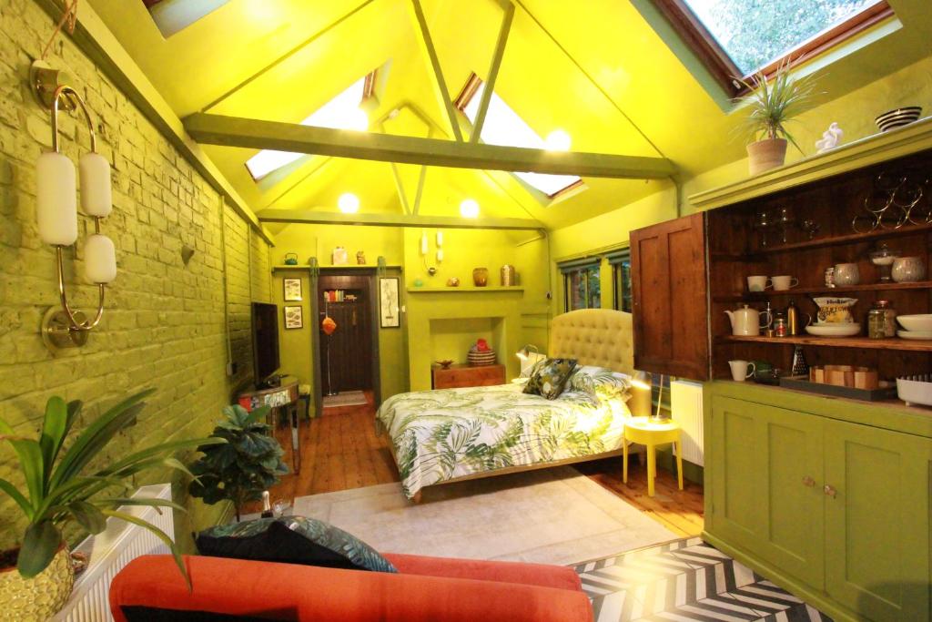 Lepine- Holiday apartment in sunny Folkestone في Kent: غرفة نوم بسرير في غرفة بجدران صفراء