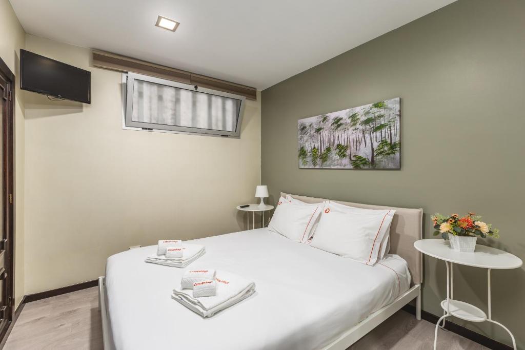ein Schlafzimmer mit einem großen weißen Bett und einem Fenster in der Unterkunft Hopstays - Gaia Cork House in Vila Nova de Gaia