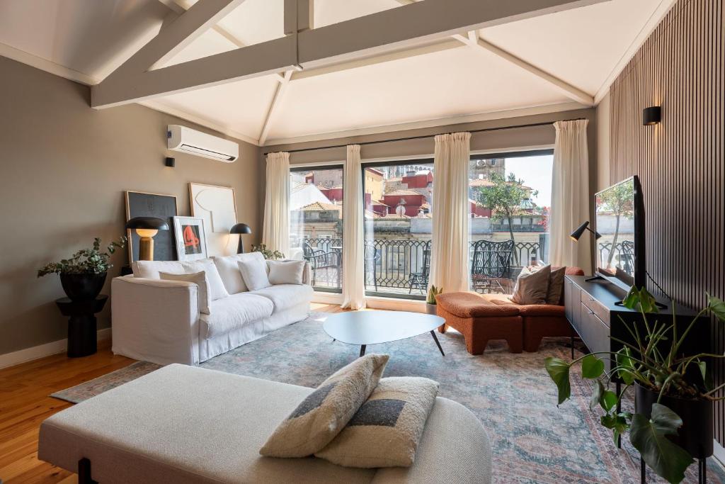 The Mouzinho Penthouse في بورتو: غرفة معيشة مع أريكة وطاولة