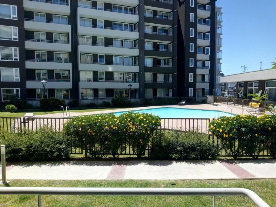 une piscine en face d'un grand bâtiment dans l'établissement Departamento en Condominio Parque Francia, à Osorno