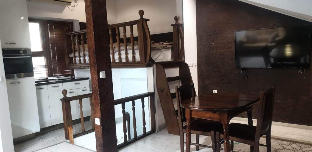 uma cozinha com uma escada de madeira com uma mesa e uma televisão em Lux Central Shumen Apartment em Shumen