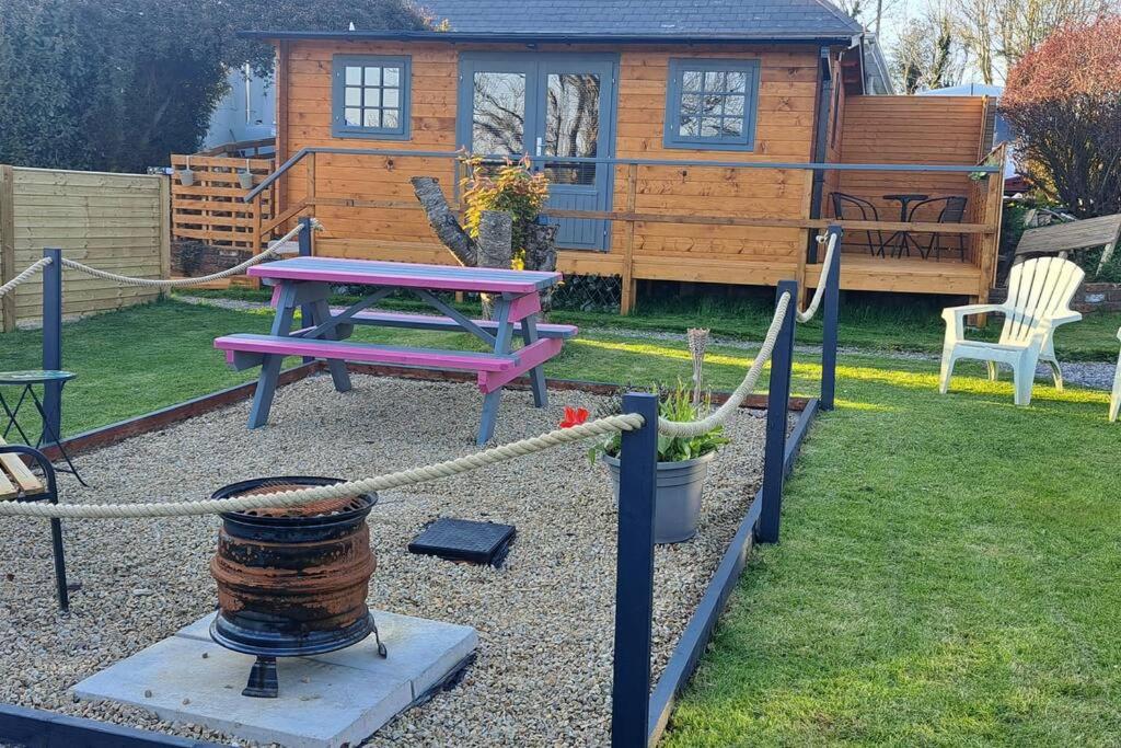 a backyard with a picnic table and a house at The Stunning Log House in Wexford