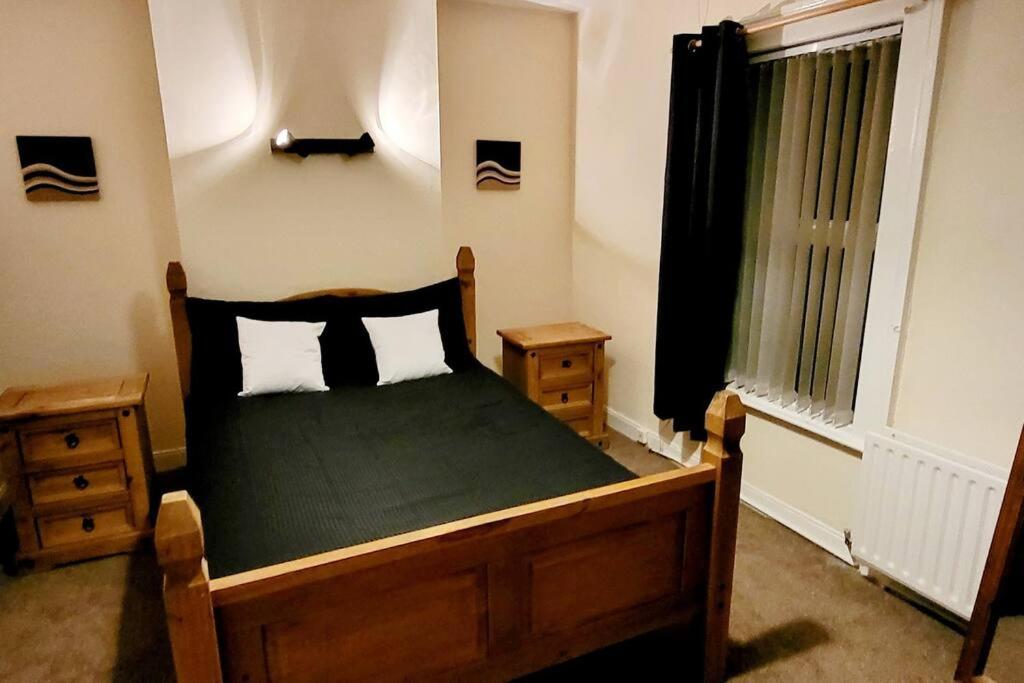 een slaapkamer met een bed met een groen dekbed en een raam bij Tods Lodge - Quiet area in Derry City in Derry Londonderry
