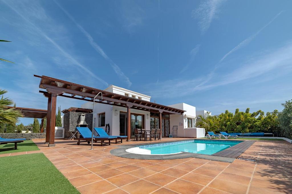 a villa with a swimming pool and a patio at Villa Alegria in Playa Blanca