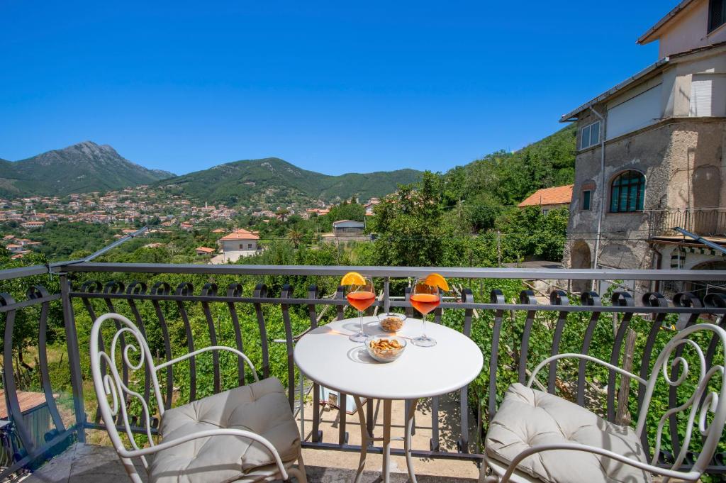 a white table with two glasses of wine on a balcony at I colori della Luna in Agerola