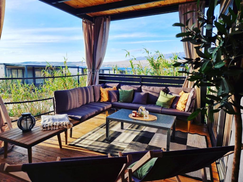 sala de estar con sofá y mesa en el balcón en Luxury Mobile Home Marbella 167 -Terra Park SpiritoS en Kolan