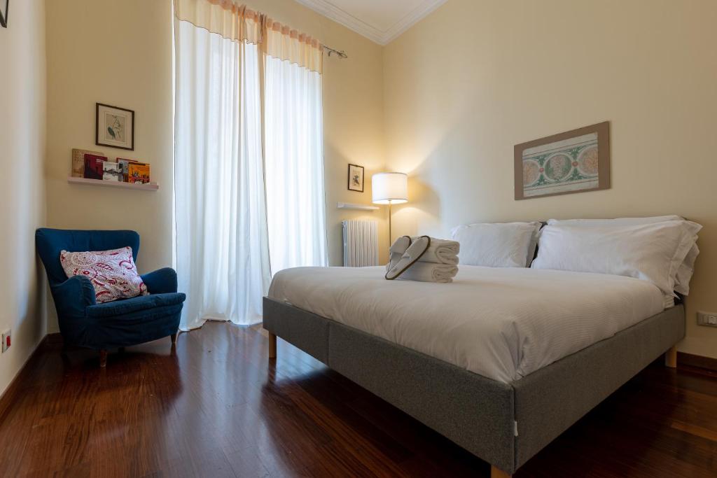 um quarto com uma cama grande e uma cadeira azul em BePlace Apartments in Lotto em Milão