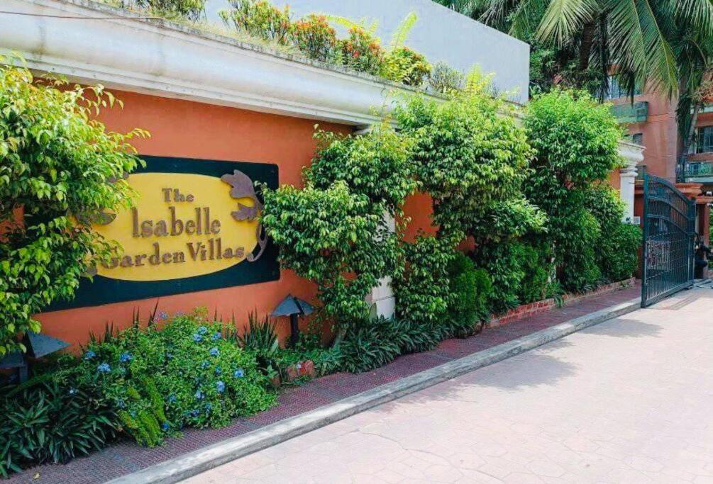 a sign on the side of a building with plants at Isabelle Garden Villas 517 in Manila