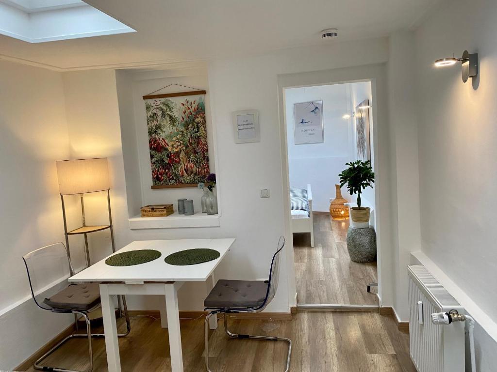 a room with a white table and chairs and a hallway at Köln City Apartments in Cologne