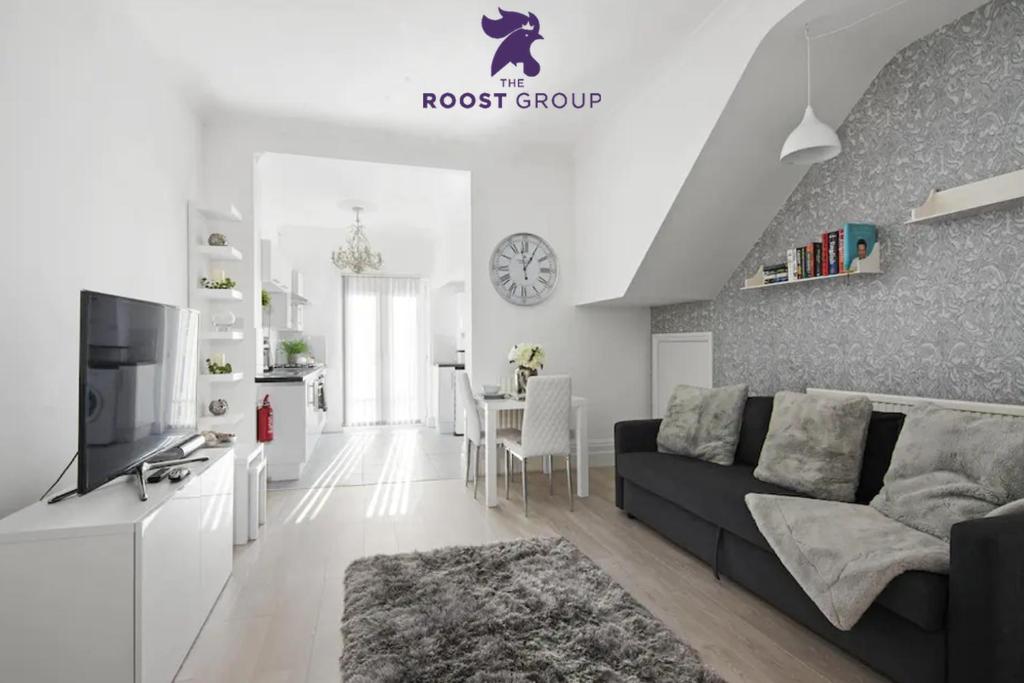 sala de estar con sofá y TV. en The Roost Group - Stylish Apartments, en Gravesend